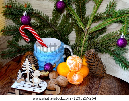 Christmas composition, which consists of Christmas tree branches, cones, mandarin, cups, candy and balls