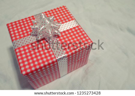 Red Gift box on the gray cloth for Christmas, new year, valentine day or anniversary day and have copy space for design in your work concept.