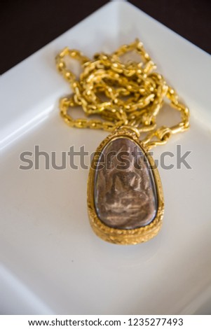 Amulet of Thailand in gold frame.