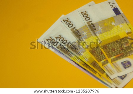two hundred euros lie on a yellow background