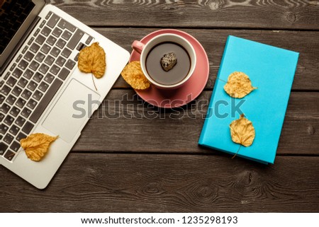 Office table with blank notebook and laptop / Coffee cup