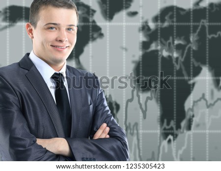 Young, beautiful, successful businessman on the world map background