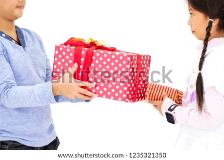 Two young Asian kids exchanging presents, white background.