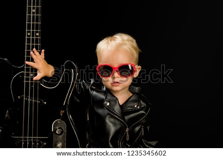 Music for everyone. Adorable small music fan. Small musician. Little rock star. Child boy with guitar. Little guitarist in rocker jacket. Rock style child. Rock and roll music performer. Royalty-Free Stock Photo #1235345602