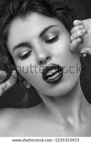 beauty portrait of young female  posing with bare shoulders on dark studio background black and white