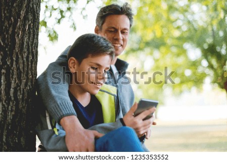 Father and son looking at mobile phone