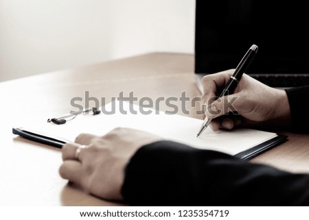 Businessman at office desk signing a contract form in office.