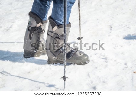 Legs wearing ski shoes wwith ski poles