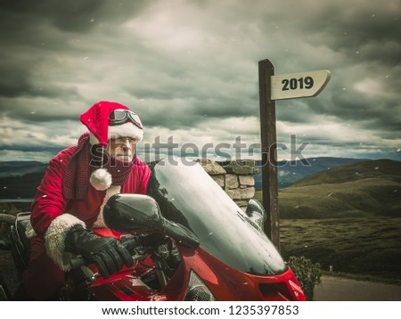 Sports Santa Claus in a hurry in 2019 on a red motorcycle against the backdrop of the winter landscapeю Royalty-Free Stock Photo #1235397853