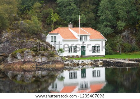 beautiful house in the reflection on the shore of the pond