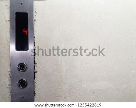 Elevator button sign on concrete wall background.