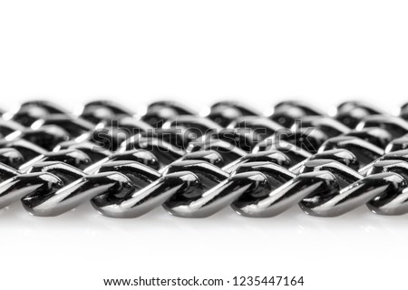 Abstract background of black decorative steel chain lying on a white background. Close-up.