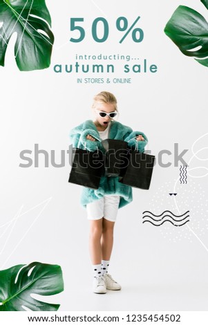 shocked kid in stylish fur coat looking into black shopping bags isolated on white, autumn sale banner concept