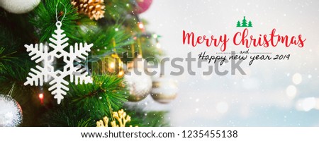 Christmas and Happy new year 2019 on blurred bokeh christmas tree background with snowfall.