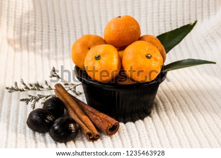 Mandarins In A Black Cup On A White Knitted Background