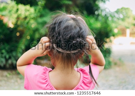 A girl scratch on her hair. The head lice makes itself at home on the kids hair.This annoying parasite can cause itching and other mild symptoms.