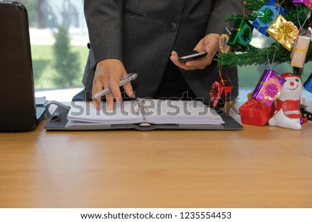 man organizing plan with notebook & smart phone. businessman working  at workplace office during christmas new year holiday