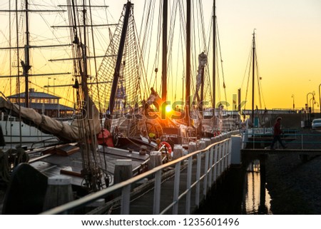 The old harbor of Harlingen in the Netherlands. Old sailboats and cargo ships with sails and masts wait for the lock to the Wadden Sea and the North Sea in the north of the Netherlands
