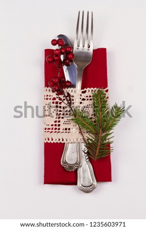 Christmas composition with cutlery, pine branch, ribbon and decorations on white table. Winter holidays and festive background. Christmas eve dinner, New Year food lunch.  top view