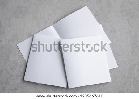 Blank portrait mock-up paper. brochure magazine isolated on gray, changeable background / white paper isolated on gray cement backdrop.