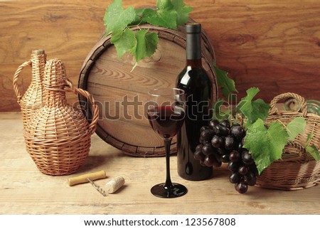 Still life with wine bottles, one glass and oak barrel