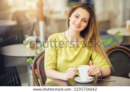 Young stylish woman with cafe. Old street in Lviv in Europe in the background
