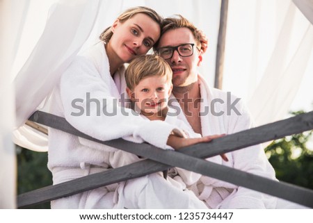 The happy family sitting on a bed together outdoor