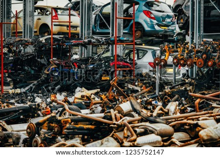 Damaged cars waiting in a scrapyard to be recycled or used for spare part Royalty-Free Stock Photo #1235752147
