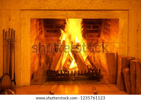 Traditional fireplace with burning firewood and charcoal in modern interior. Beautiful view fire in fireplace create warm and cozy picture. background for design. Christmas New Year concept decoration