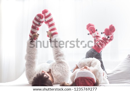 Christmas and new year concept, mom and daughter play in a homely atmosphere on the sofa in the living room, family values
