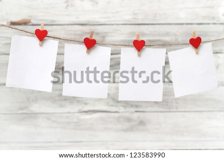 blank instant paper hanging on the clothesline on wooden background