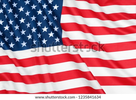 A star-striped American flag waving in the wind. The pride of the American people. Symbol of independence and patriotism in the United States.