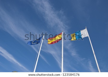 The Flags of the European Union,Spain and the Canary Islands under a blue sky