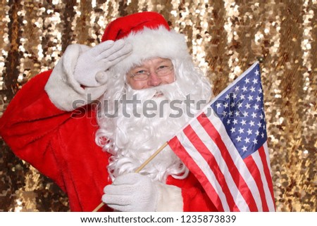 Santa Claus. Santa Claus holds an American Flag. Santa is all American. Gold Sequin background. Christmas Images.