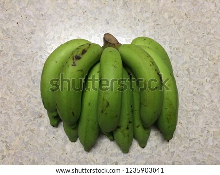 Bananas are raw from banana trees.Green bananas on the marble floor.Sweet Thai fruit.Green bananas for Healthy and dieting.Asia fruit.