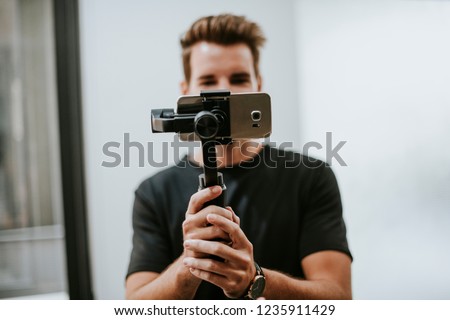 Man holding a gimbal with a phone Royalty-Free Stock Photo #1235911429