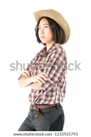 Young pretty woman in a cowboy hat and plaid shirt with arms crossed isolated on white background
