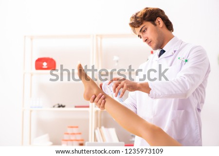 Male doctor checking joint flexibility with goniometer 