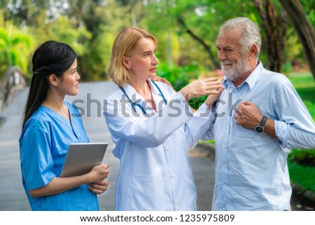 Senior man talking to doctor, nurse or caregiver in the park. Mature people healthcare and medical staff service concept.