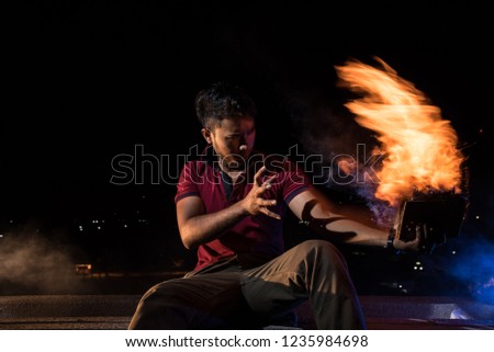 Asian dark make ages 24 wear dark red shirt and tactical pants holding fire in left hand