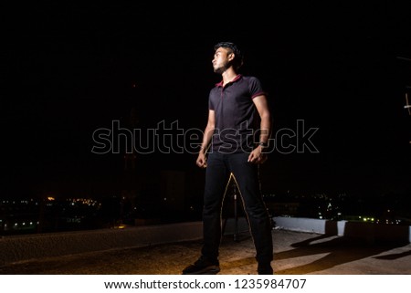 Asian dark make ages 24 wear dark shirt black pants face up standing in darkness