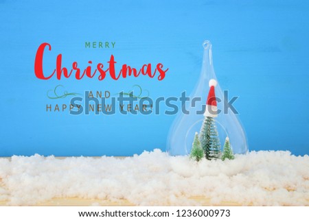 Christmas image of christmas trees inside glass over wooden table
