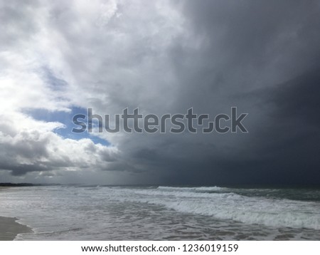 Dramatic contrast between light and dark on the beach. Stormy weather coming.