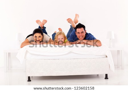 beautiful young family lying on bed