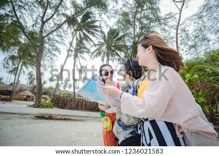 Group of happy young friends in summer clothes taking a selfie while standing at the beach Friendship Young happy tourists in sea using map