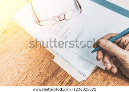 Hand signing papers for formal business signature.  Finance and monetary agreement.