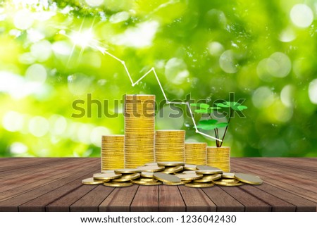stack of coins and tree on wooden table with bokeh nature background,Lucky economic growth concept