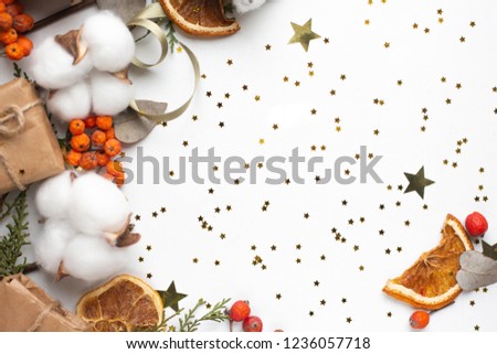 Eucalyptus leaves and cotton flowers and gift boxes on white background and red berries. Flat lay, top view. craft minimalistic presents