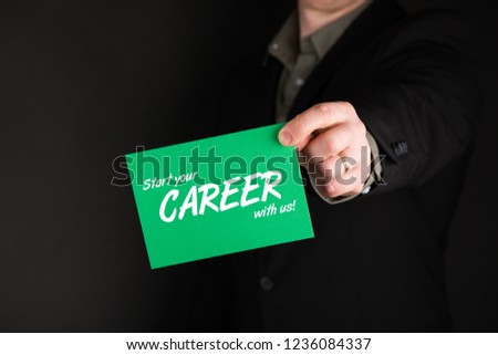 Businessman holding green card with text "Start your Career with us", man in suit, black background, Concept job recruitment and human resource