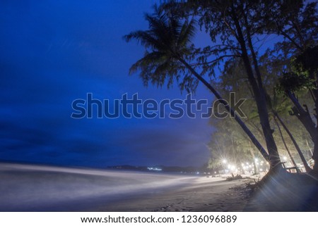 The background of light from Beach restaurant at night, with chairs, table to sit, with customer service, during the turbulent sea and continuous rain.